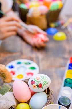 Annem Nisan 'da Paskalya kutlaması için yumurta boyuyor. Aile kutlaması ve ev dekorasyonu için resim ve hazırlık.