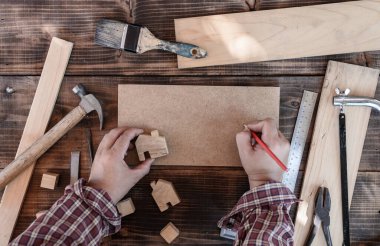 Marangoz dükkanında çalışan bir marangoz. Diy marangozluk ve ev konseptinde çalışmak. Sosyal Mesafe veya Fiziksel Mesafe.