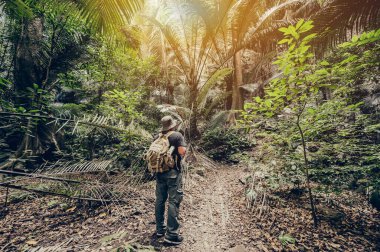 Kuş gözlemi ve orman ve mağarada yürüyüş için dürbün tutan maceraperest. Yaz tatilinde açık hava aktivitesi ve dinlenme.