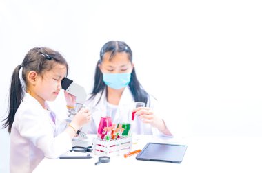 Çocuklar, Anti-Covid-19 önlemlerini öğrenmek için deney yapıyorlar. Çocuklar iş hayali kurar. Bilim ve kimya alanında çalışan genç Asyalı bilim adamı.