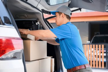 Taylandlı postacı paket ve posta kutularını kontrol ediyor. Asya çevrimiçi alışveriş servisi.