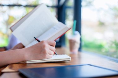 Öğrenci kitap okuyor ve kağıda yazıyor. Tatilde evde dinlenmek ve dinlenmek. Eğitim ve eğitim kavramı.