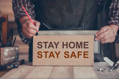 WFH: Carpenter evden çalışıyor. Evde kal. Güvenli ahşap işçiliği konsepti. Sosyal Mesafe ve Fiziksel Mesafe