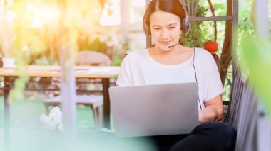 Evden çalışmak (WFH). Ev bahçesinde çalışan çekici Asyalı kadın.