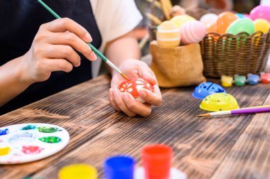 Annem Nisan 'da Paskalya kutlaması için yumurta boyuyor. Aile kutlaması ve ev dekorasyonu için resim ve hazırlık.