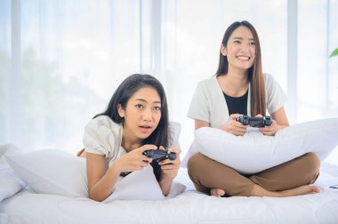 Online oyun oynamak ve kazanmak için takım çalışması yapmak. Taylandlı bir arkadaşla Asyalı kadın yaşam tarzı. Sosyal mesafeyi koru ve evde kal..