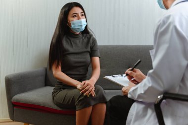 Akıl sağlığı. Psikolog hastaya tavsiye ediyor. Coronavirus ya da Covid-19 'un Tayland, Asya' daki iş kayıpları sırasında ekonomik sorunların işsizliği. Klinikte çalışan doktor..