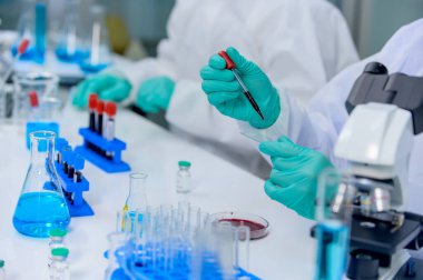 Bilim adamı ekibi Coronavirus tedavisini araştırıyor ve üzerinde çalışıyor. Asyalı Doktor, virüs enfeksiyonuna karşı numuneleri inceleyip aşı uyguluyor..