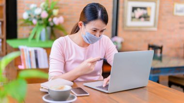 İnternetten Asyalı kadın alışverişi. Sosyal uzaklık ve yeni normal yaşam tarzı.