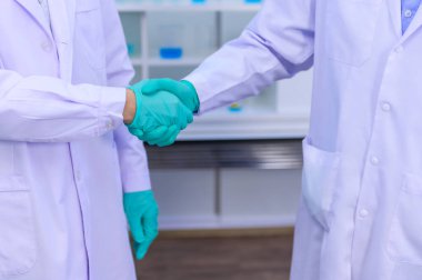 Bilim adamları Coronavirus tedavisini laboratuvarda araştırmanın başarısı için el sıkışırlar. Asyalı Doktor virüs enfeksiyonuna karşı aşı üzerinde çalışıyor.