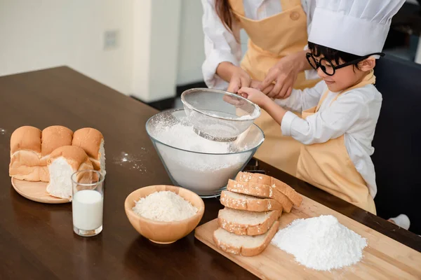 Mom teaching son for cooking food. Mother and kid daily lifestyle at home. Asian family together in the kitchen.