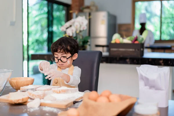 Mom teaching son for cooking food. Mother and kid daily lifstyle at home. Asian family together in the kitchen.