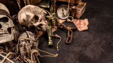 İnsan kafataslı bir korsan. Hazine sandığı ve altın. Keşif ekipmanları ve kayıp servet kaşifi..