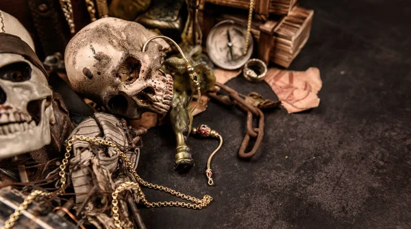 İnsan kafataslı bir korsan. Hazine sandığı ve altın. Keşif ekipmanları ve kayıp servet kaşifi..