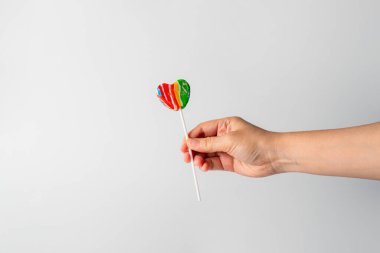 Sweets, lollipops in hand, on white background