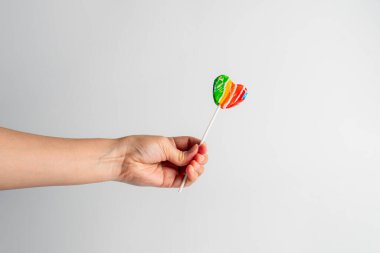 Sweets, lollipops in hand, on white background