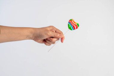 Sweets, lollipops in hand, on white background