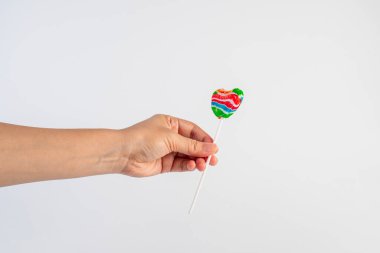 Sweets, lollipops in hand, on white background