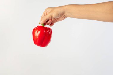 Red sweet bell pepper in hand isolated on white background