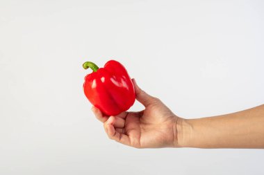 Red sweet bell pepper in hand isolated on white background