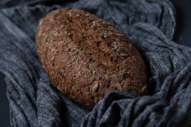 Bütün tahıl ekmeği ile tohum gri kumaş dokulu yüzeyi üzerinde