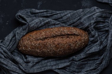 Bütün tahıl ekmeği ile tohum gri kumaş dokulu yüzeyi üzerinde