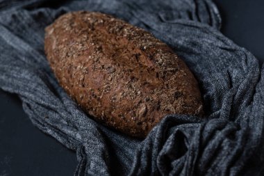 Bütün tahıl ekmeği ile tohum gri kumaş dokulu yüzeyi üzerinde