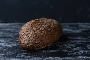 Bütün tahıl ekmeği ile tohum gri kumaş dokulu yüzeyi üzerinde