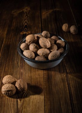 Rustik tarzı ahşap bir yüzey üzerinde eski bir kapta ceviz