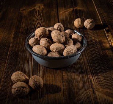 Rustik tarzı ahşap bir yüzey üzerinde eski bir kapta ceviz