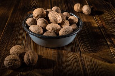 Rustik tarzı ahşap bir yüzey üzerinde eski bir kapta ceviz