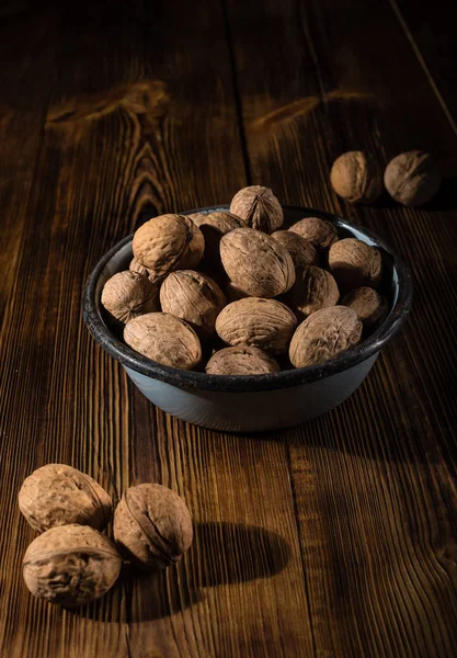 Rustik tarzı ahşap bir yüzey üzerinde eski bir kapta ceviz