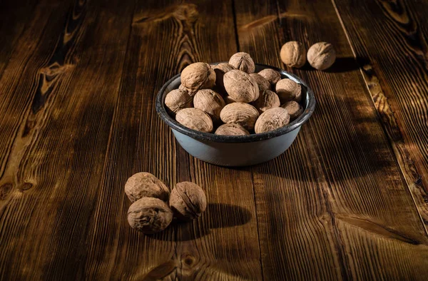 Rustik tarzı ahşap bir yüzey üzerinde eski bir kapta ceviz