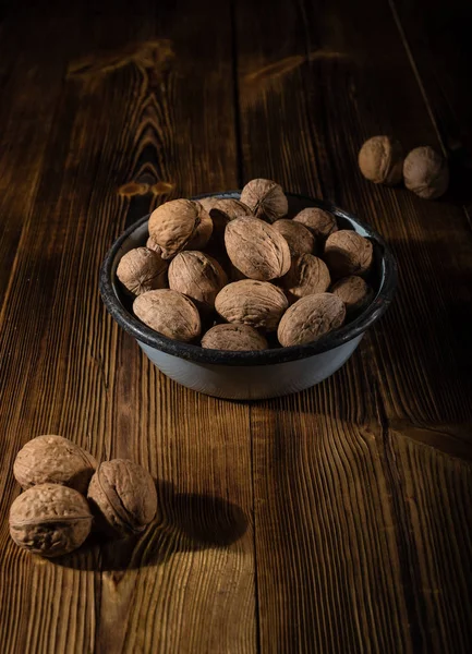 Rustik tarzı ahşap bir yüzey üzerinde eski bir kapta ceviz