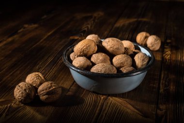 Rustik tarzı ahşap bir yüzey üzerinde eski bir kapta ceviz