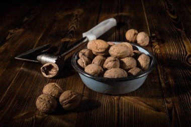 Rustik tarzı ahşap bir yüzey üzerinde bir mutfak balta ile eski bir kapta ceviz