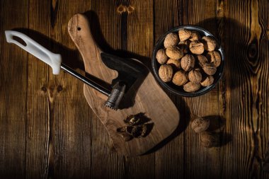 Rustik tarzı ahşap bir yüzey üzerinde bir mutfak balta ile eski bir kapta ceviz