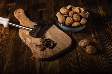 Rustik tarzı ahşap bir yüzey üzerinde bir mutfak balta ile eski bir kapta ceviz