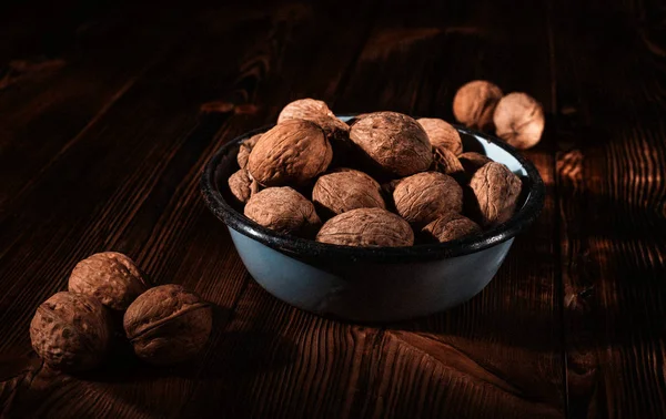 Rustik tarzı ahşap bir yüzey üzerinde eski bir kapta ceviz