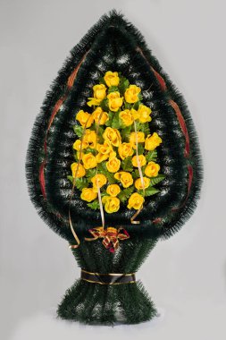 Üzerinde yapay çiçekler olan gri bir sepet.