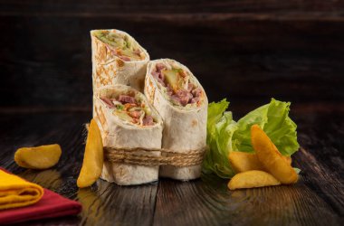 Doner kebabı, şavurma, sade patates ve ahşap bir arka planda lahana.