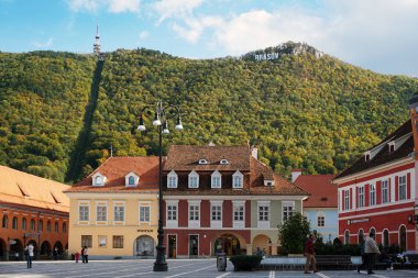 Brasov, Romanya - 4 Ekim 2018: Ana Meydanı, Brasov. Dağın arka planda şehir adını taşıyan tarihi binalar.