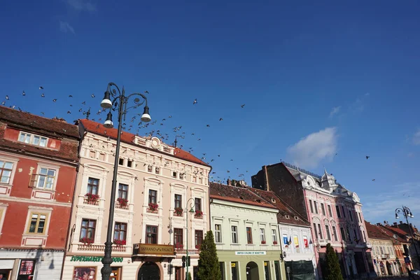 Brasov, Rumania - 3 de octubre de 2018: Edificios antiguos en la plaza principal de Brasov sobre un fondo de cielo azul . — Foto de Stock