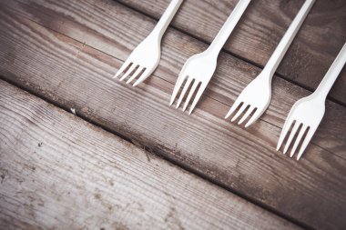 Ahşap arka plan plastik ücretsiz kavramı üzerinde beyaz plastik çatal