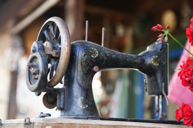 Old sewing machine with red geranium clipart
