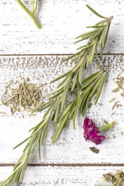 Taze ve kuru biberiye otlar üzerinde rustik masa üstü ile Yenilebilir çiçekler