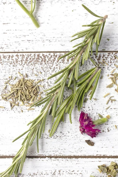 Taze ve kuru biberiye otlar üzerinde rustik masa üstü ile Yenilebilir çiçekler