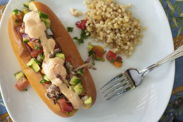 Hotdog i wyciągnął wieprzowinę na kok zwieńczony izraelską sałatką i dr — Zdjęcie stockowe