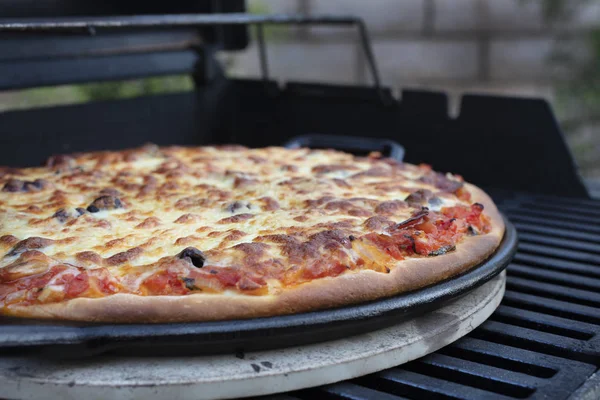Pepperoni, kaas en tomaat pizza worden gemaakt op een Cast Iron ski — Stockfoto