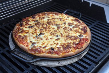 Pepperoni, peynir ve domates pizza dökme demir kayak yapılıyor